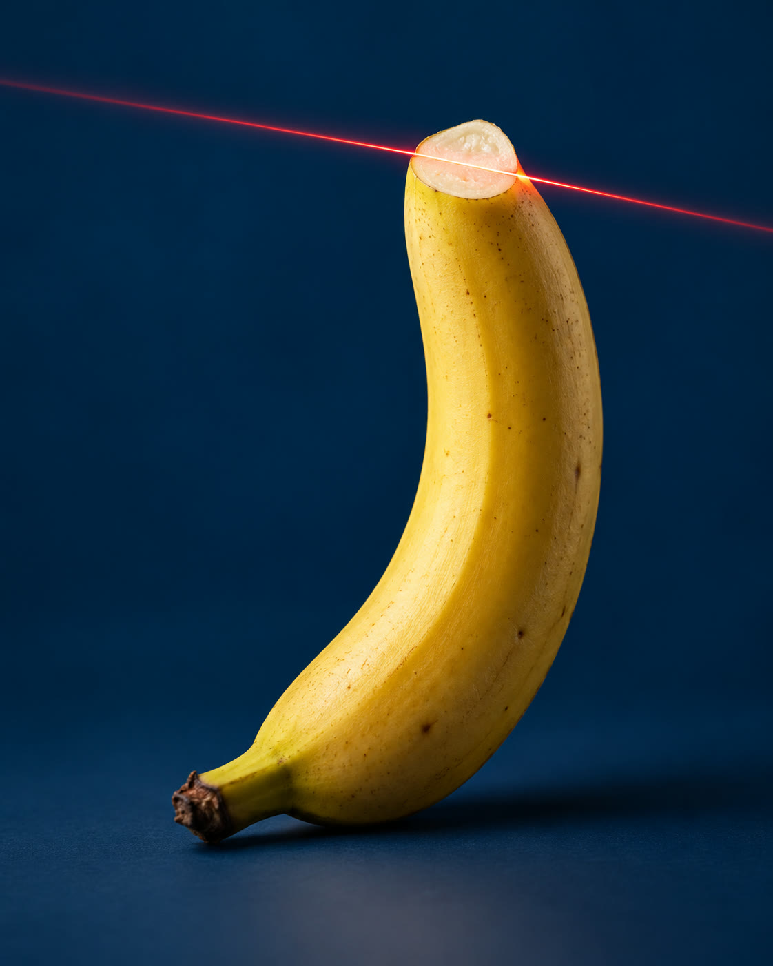Banana com a ponta cortada por um feixe de laser vermelho